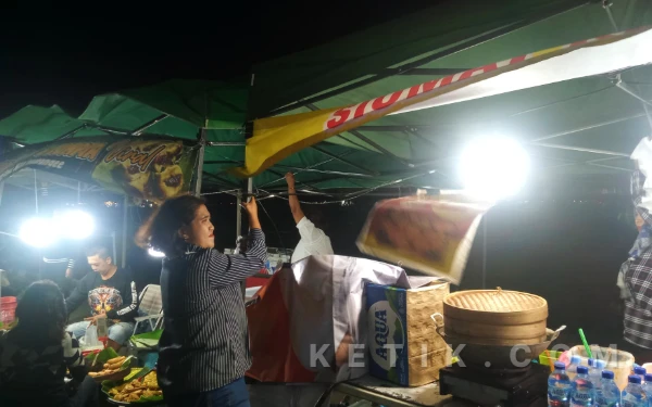 Thumbnail Diterjang Angin Kencang, Pedagang Pasar Senggol Rampal Bertahan Pegangi Tenda