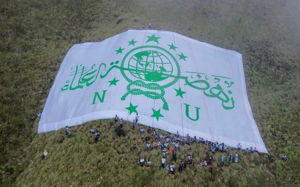 Thumbnail Berita - Tembus Hujan dan Medan Terjal, 100 Kader NU Kota Batu Bentangkan Bendera Raksasa di Gunung Panderman