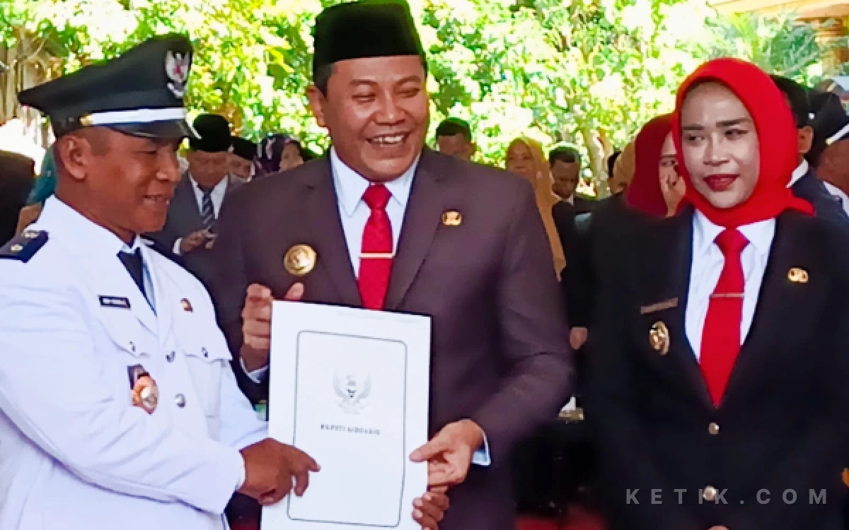 Foto Bupati Subandi menyerahkan SK kepada Kades Siwalan Panji, Kecamatan Buduran, M. Khoiron didampingi Wabup Mimik Idayana. (Foto: Fathur Roziq/Ketik.com)