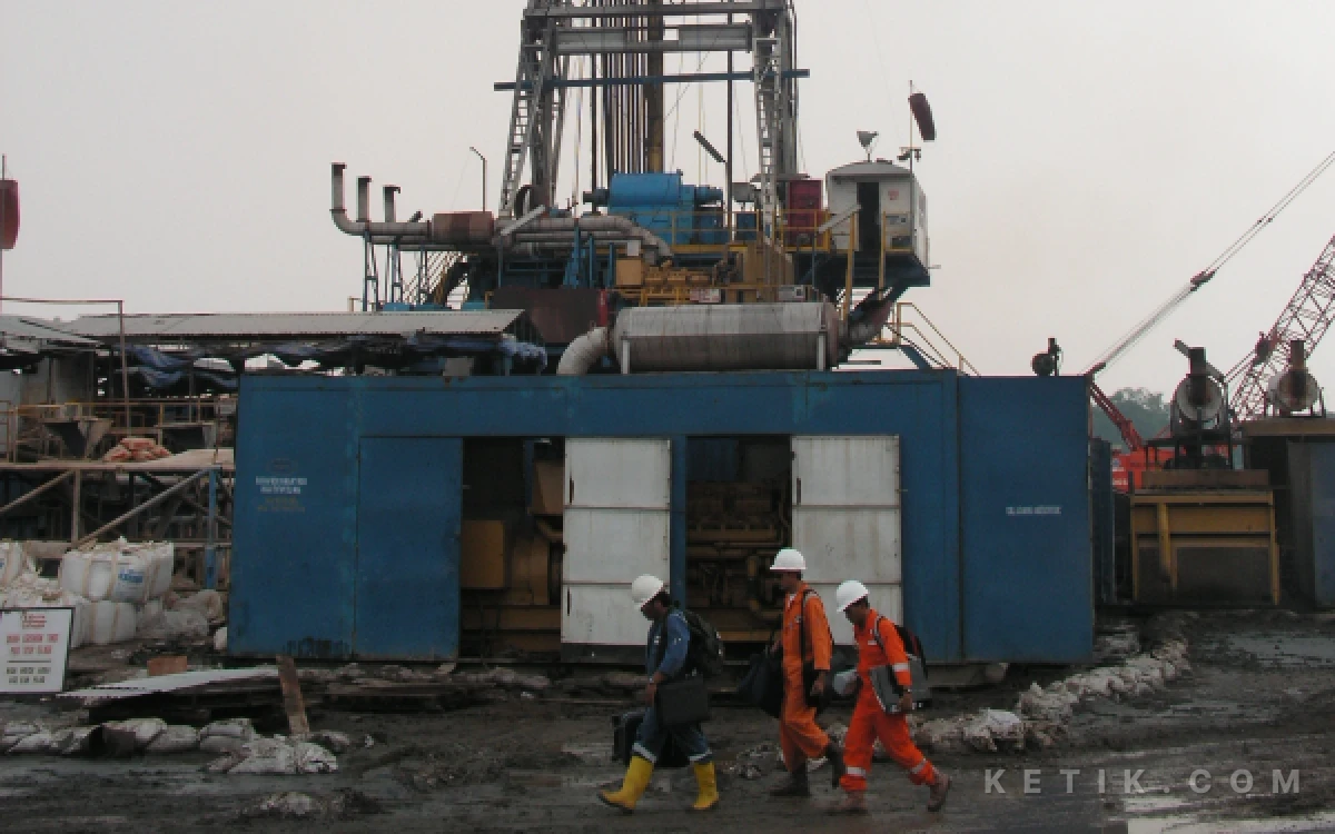 Foto Beberapa pekerja melangkah pergi dari lokasi pengeboran, melewati rig yang masih berdiri tegak di Desa  Renokenongo, Kecamatan Porong.   Gambar diambil pada Jumat, 2 Juni 2006. (Foto: Dokumen Fathur Roziq).