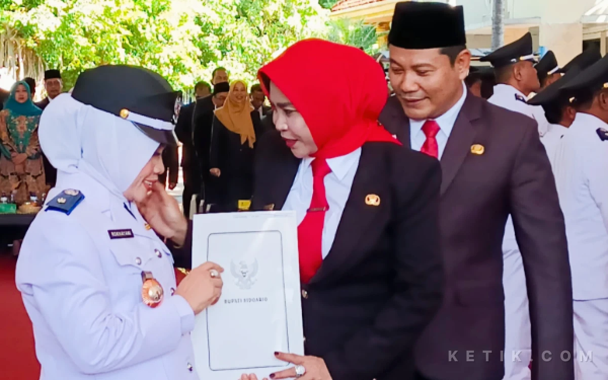 Foto Wabup Mimik Idayana memasangkan tand pangkat dan lencana Bu Kades setelah pengambilan sumpah di Pendopo Delta Wibawa pada Senin (29 Juni 2026). (Foto: Fathur Roziq/Ketik.com)