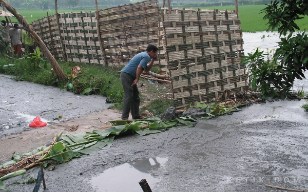 Foto Warga Desa Renokenongo, Kecamatan Porong, mengintip lokasi pusat semburan setelah gotong royong memasang blokade gedhek yang akhirnya ditembus aliran lumpur panas.  Foto diambil 2 Juni 2006. (Foto: Dokumen Fathur Roziq)