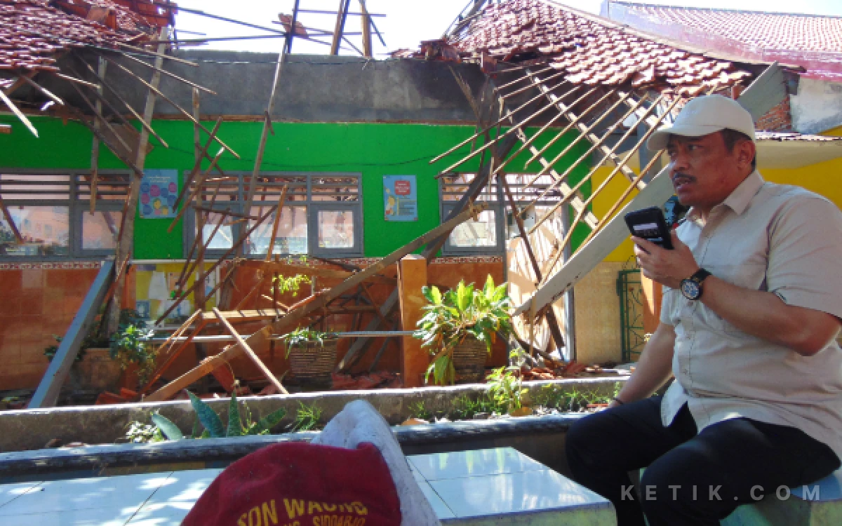 Foto Ketua Komisi D DPRD Sidoarjo Dhamroni Chudlori menelepon pejabat Disdikbud Sidoarjo untuk meminta kepastian pembangunan kembali ruang kelas SDN Waung Krembung yang ambruk. (Foto: Fathur Roziq/Ketik.com)